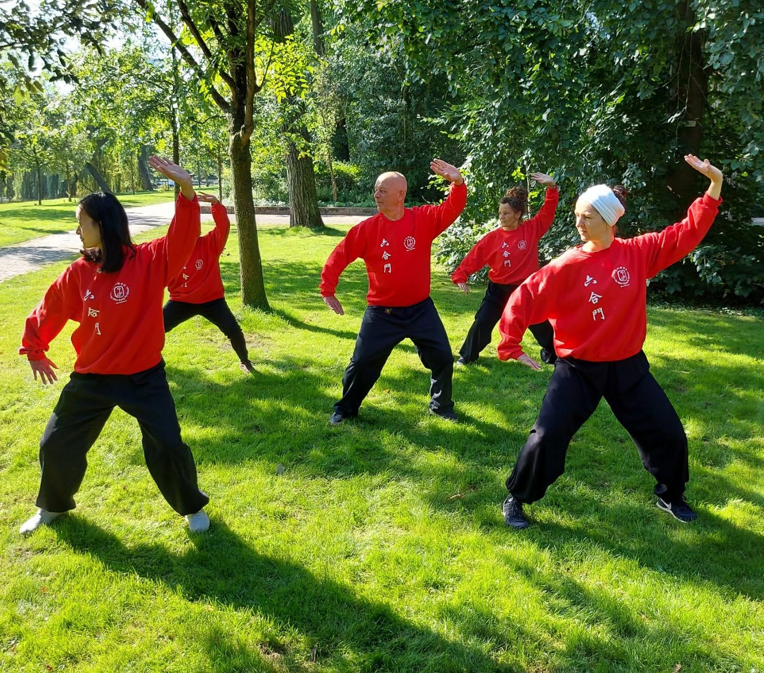 Internal martial arts people training dressed in red at the park_
